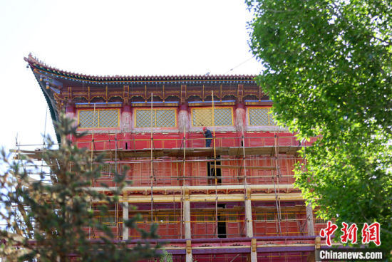 圖為5月上旬，甘肅山丹縣大佛寺內(nèi)，工作人員對(duì)古建筑大雄寶殿進(jìn)行修繕。 中新社記者 高展 攝