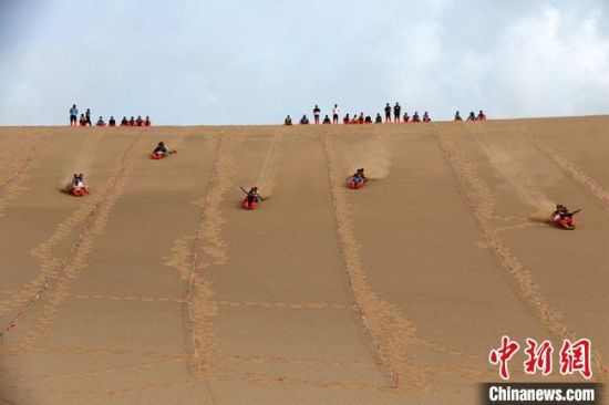 6月13日，敦煌鳴沙山月牙泉景區(qū)舉辦滑沙比賽?！垥粤?攝
