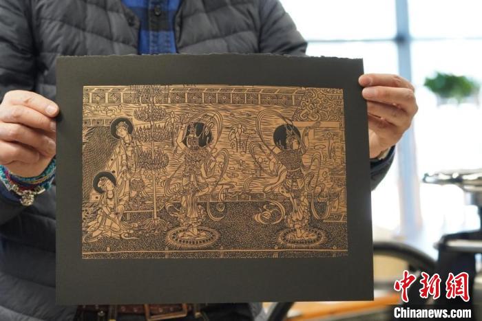 圖為手工書藝人展示敦煌雕版壁畫印刷品?！【琶赖┰?　攝