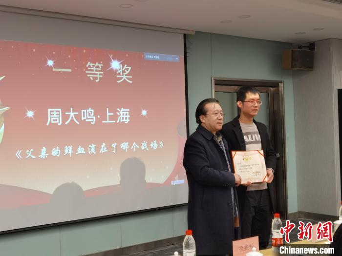 圖為作家、西北師范大學新聞與傳媒學院院長徐兆壽頒發(fā)一等獎證書，代領(lǐng)獎者上臺領(lǐng)獎?！钅?攝