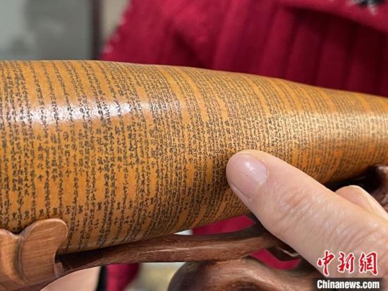 圖為長約二十公分的長條葫蘆雕刻佛教經(jīng)文作品?！堟?攝