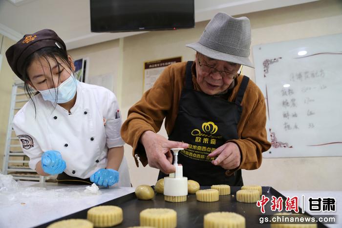 當(dāng)日，受邀參加活動(dòng)的臺(tái)胞臺(tái)屬代表、兩岸婚姻及子女、在甘臺(tái)商代表等歡聚一堂。圖為77歲的在甘臺(tái)胞潘天鑒制作月餅。九美旦增 攝