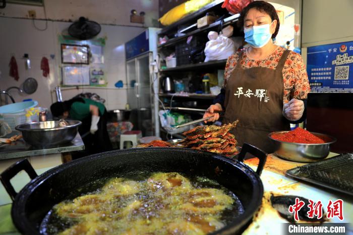 圖為平安驛·河湟民俗文化體驗(yàn)地內(nèi)的商戶炸干板魚(yú)?！⊙Φ?攝