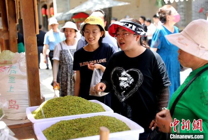 圖為民眾購(gòu)買(mǎi)青海特色小吃?！⊙Φ?攝
