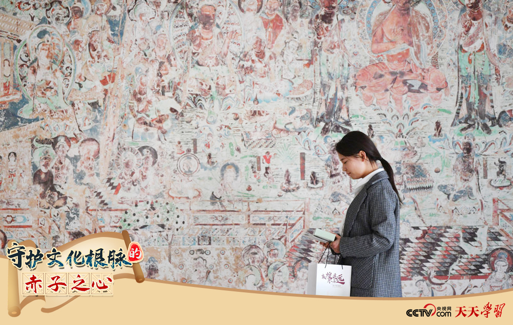 2023年4月25日，敦煌研究院文物數(shù)字化保護(hù)團(tuán)隊(duì)創(chuàng)意營(yíng)銷(xiāo)人員廖雪婷從一幅高保真復(fù)制壁畫(huà)前走過(guò)。