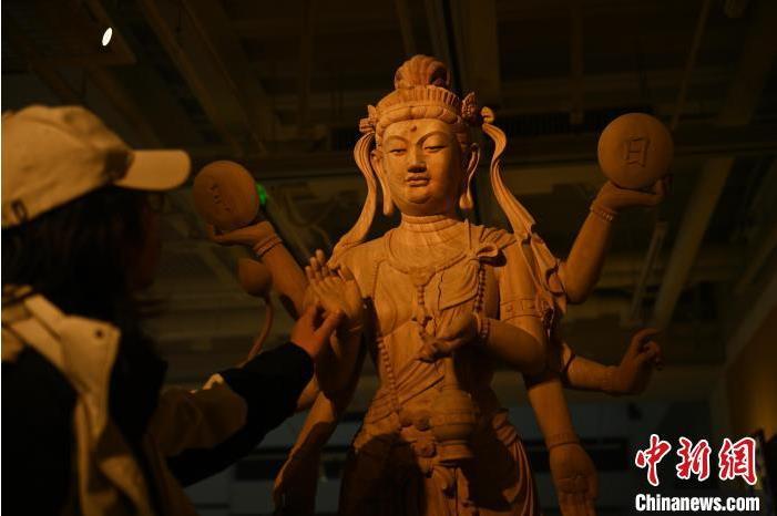圖為季茂杰觀察自己創(chuàng)作的敦煌木雕。李亞龍 攝</p>
<p>