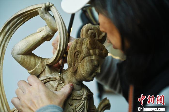 圖為季茂杰進(jìn)行敦煌元素的木雕創(chuàng)作。李亞龍 攝</p>
<p>