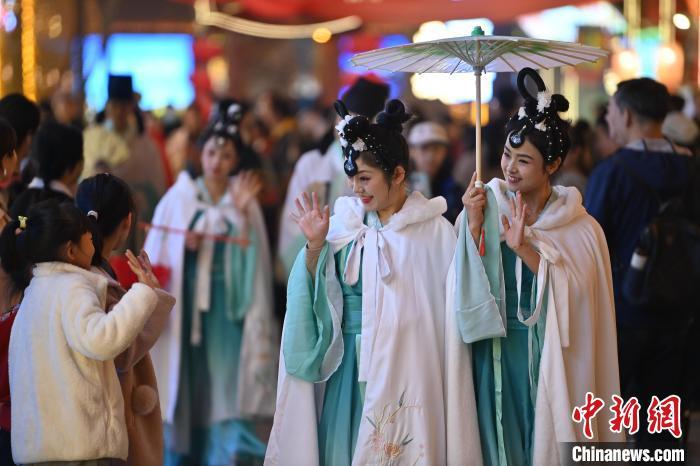 圖為街區(qū)人員著傳統(tǒng)服飾與游人互動。李亞龍 攝</p><p>