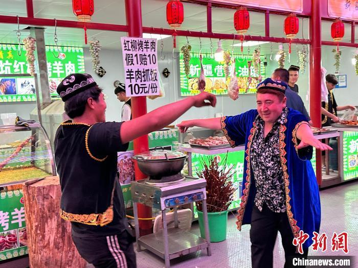 圖為餐飲經(jīng)營(yíng)者在“西涼不夜城”跳起舞蹈引客。　戴文昌 攝</p><p>
